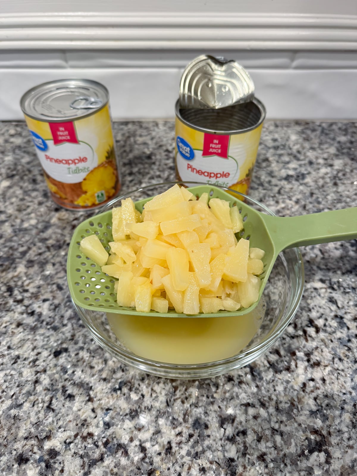 draining pineapple bits over a bowl.