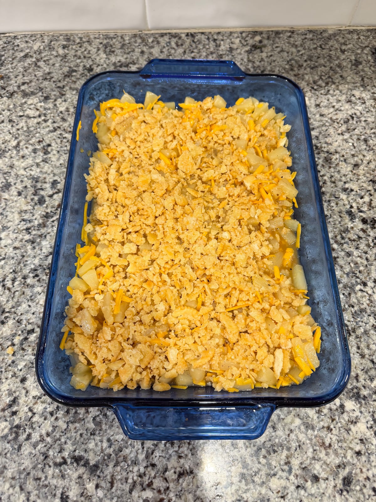 pineapple and cheese casserole in a baking dish before going into the oven to bake.