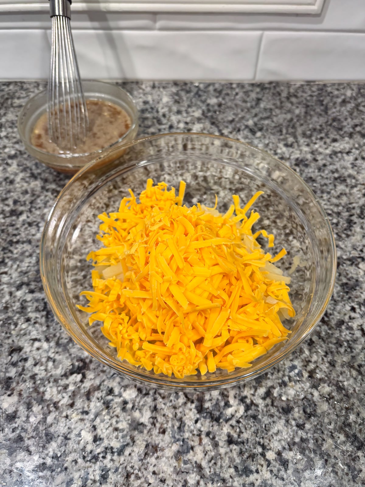 adding shredded cheese to pineapple in a large bowl.
