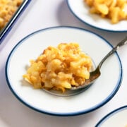a scoop of pineapple cheese casserole on a small blue plate