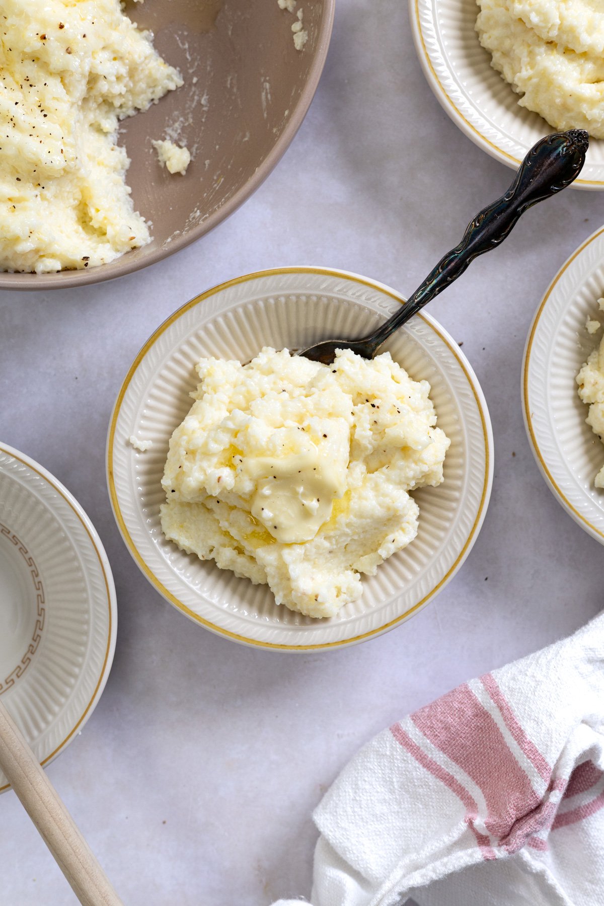 what grits in small bowls with a spoon and butter on top