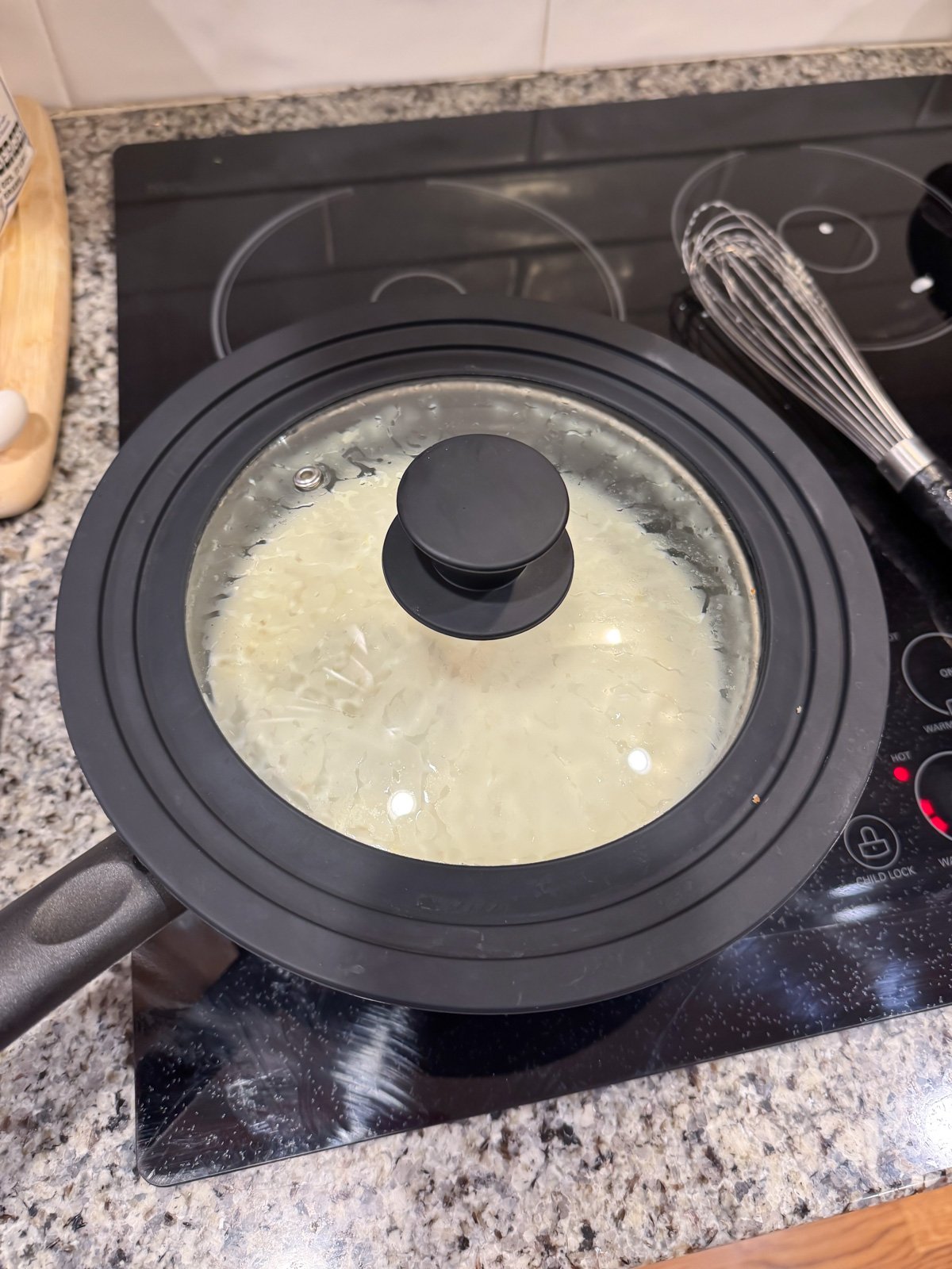 putting a lid on grits that are cooking on the stove.