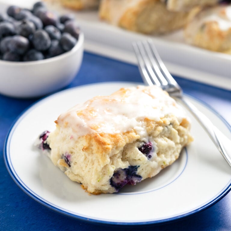 a small plate with a blueberry buttermilk biscuit and a fork on it.