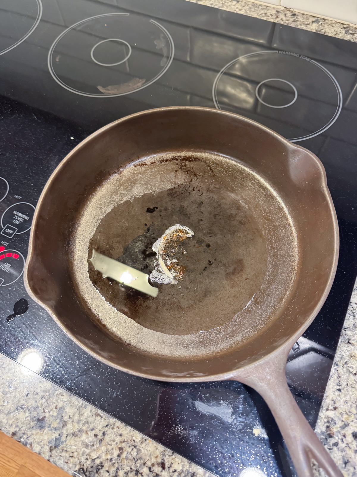 bacon grease melted in a cast iron skillet on the stove.