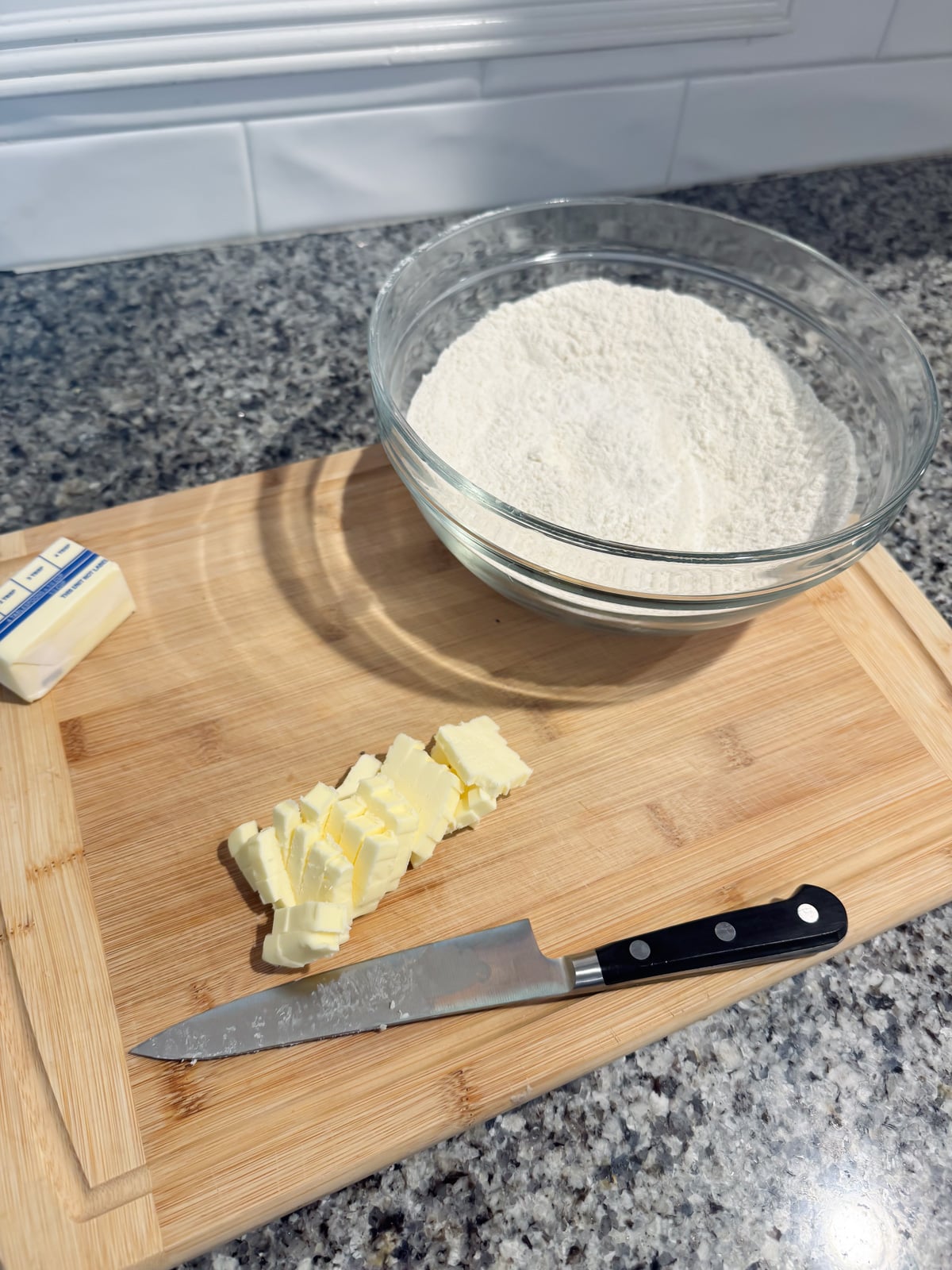 cutting butter into cubes on a cutting board.