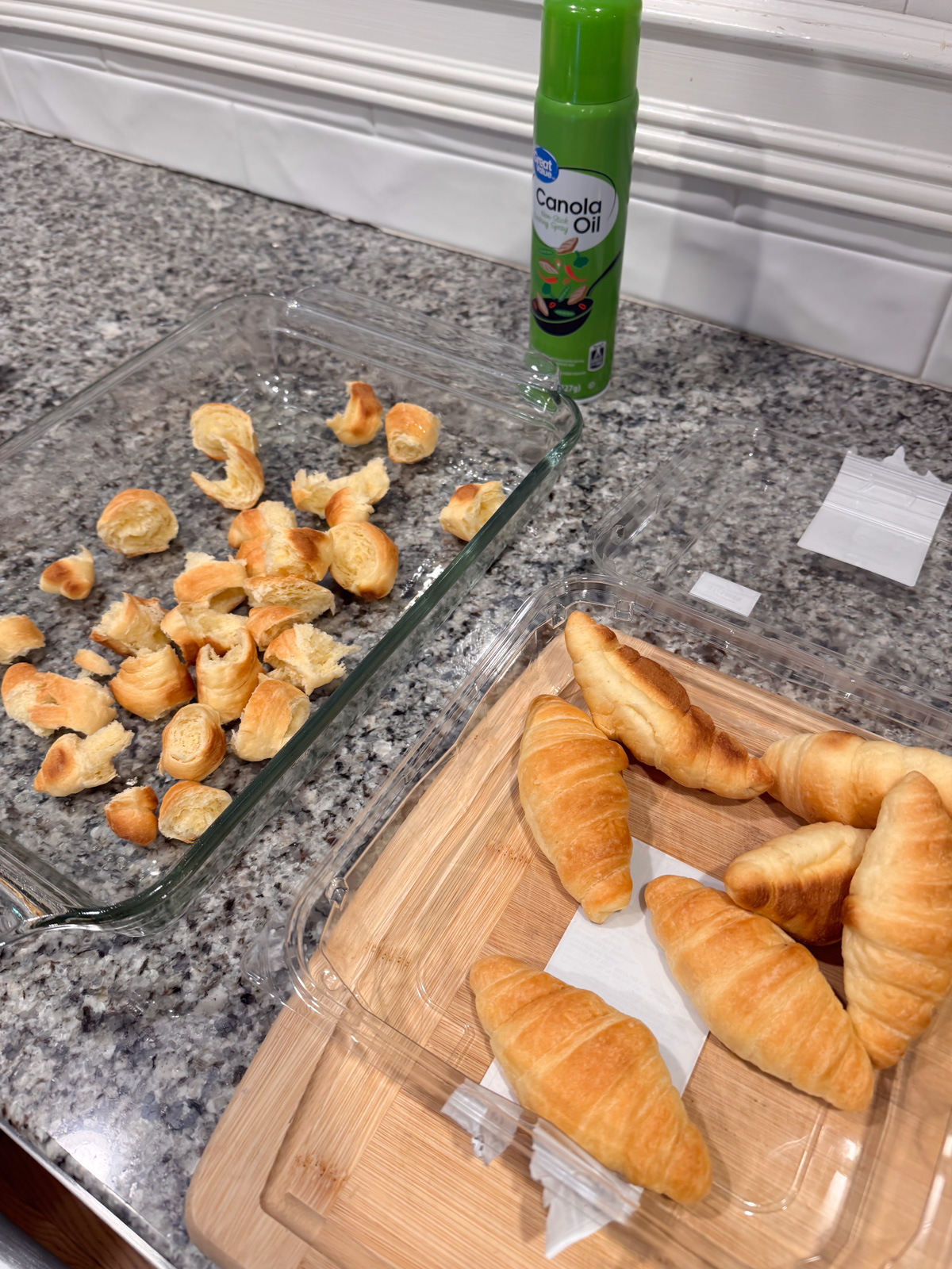 Tearing up croissants and adding them into a baking dish.