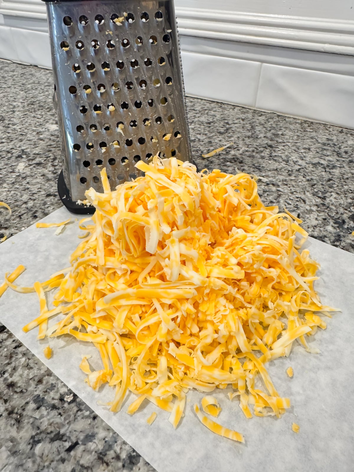 a block of Colby jack shredded on a piece of parchment paper